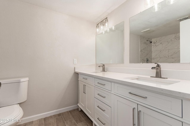 bathroom with visible vents, toilet, baseboards, and a sink