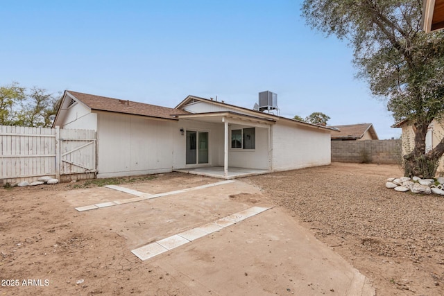 back of property with a patio, central AC unit, and a fenced backyard