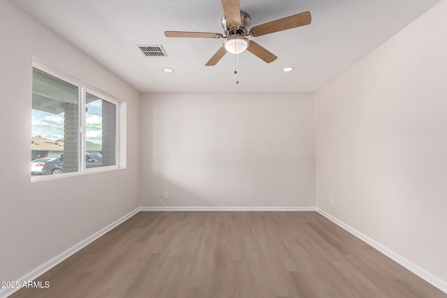 empty room with visible vents, recessed lighting, baseboards, and wood finished floors