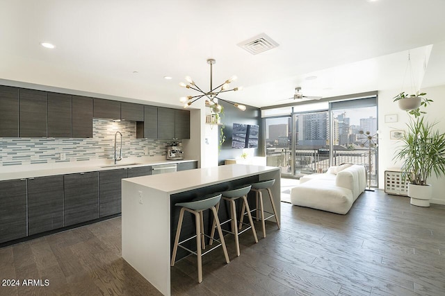 kitchen featuring sink, dark wood-type flooring, floor to ceiling windows, a breakfast bar, and a kitchen island