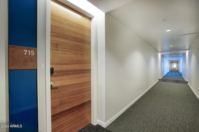 hallway featuring dark colored carpet