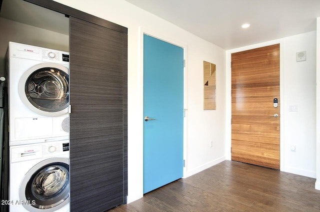 clothes washing area featuring dark wood-type flooring and stacked washer / drying machine