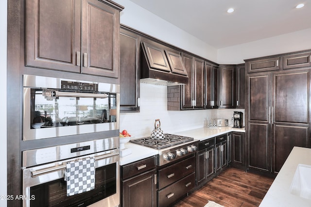 kitchen with stainless steel appliances, dark wood-type flooring, and light countertops