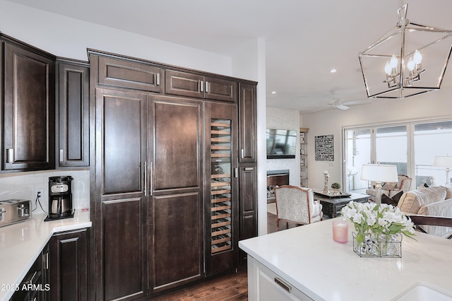 kitchen featuring dark wood finished floors, open floor plan, light countertops, and dark brown cabinetry