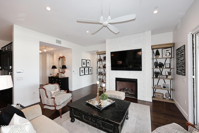 living area with wood finished floors, recessed lighting, a ceiling fan, and a large fireplace