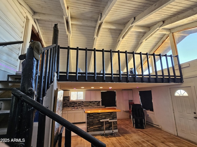 staircase with sink, beamed ceiling, high vaulted ceiling, wooden ceiling, and hardwood / wood-style flooring