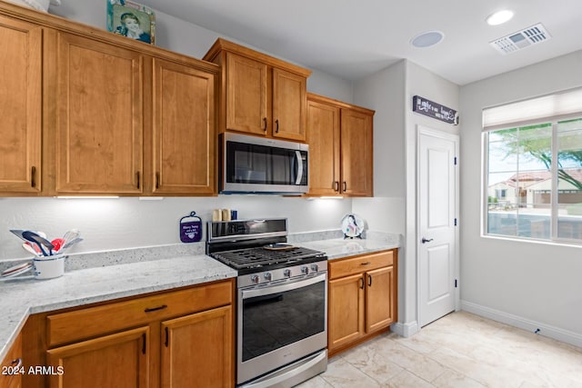 kitchen featuring light stone counters and appliances with stainless steel finishes