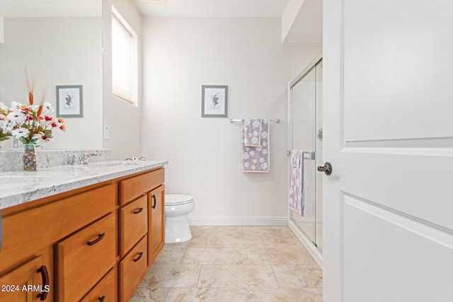 bathroom with vanity, toilet, and a shower with shower door