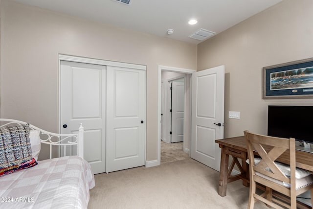 bedroom with light carpet and a closet