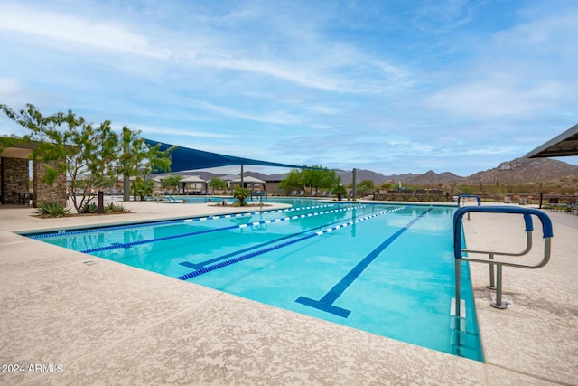 view of swimming pool with a patio area and a mountain view