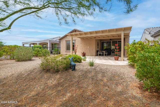 back of property with ceiling fan and a patio