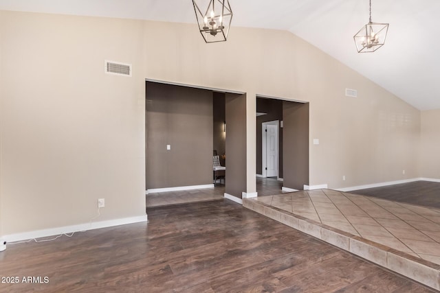 interior space with an inviting chandelier, dark hardwood / wood-style flooring, and high vaulted ceiling