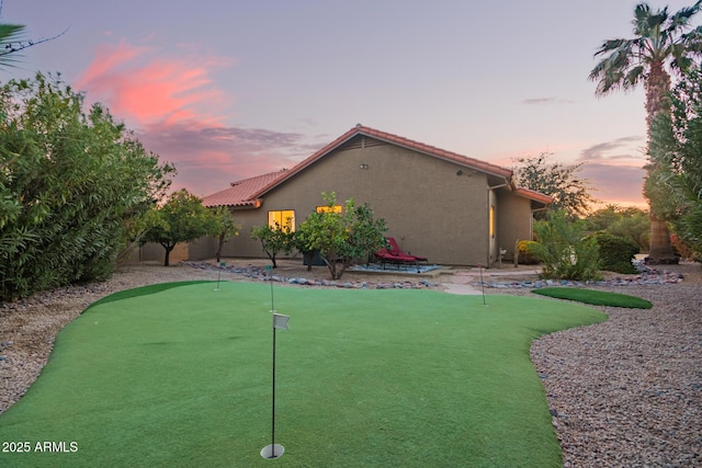 yard at dusk featuring a patio