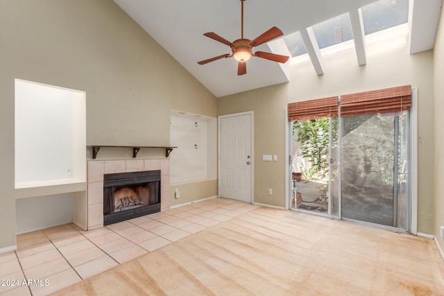 unfurnished living room with ceiling fan, a tiled fireplace, high vaulted ceiling, baseboards, and tile patterned floors
