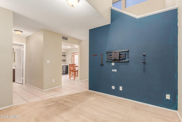 interior space with tile patterned floors, baseboards, a textured ceiling, and visible vents
