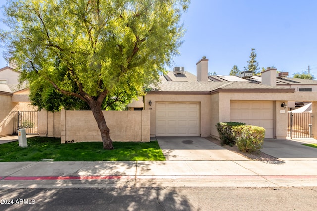 view of front of home featuring a garage and central air condition unit