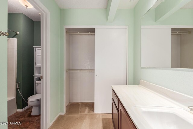 full bathroom with vanity, a spacious closet, and toilet