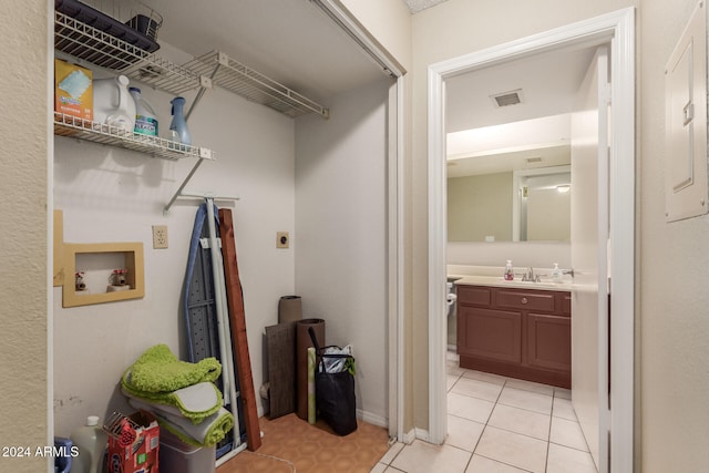 laundry area featuring sink, electric dryer hookup, light tile patterned floors, and hookup for a washing machine