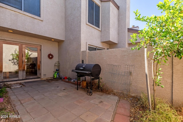 view of patio with fence, area for grilling, and french doors