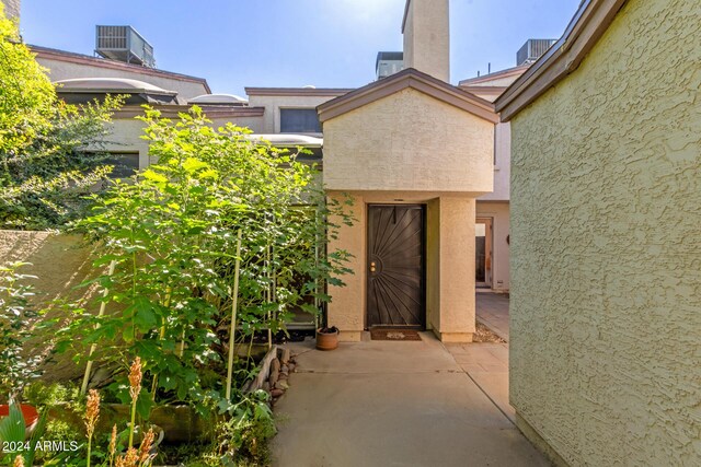 doorway to property featuring central air condition unit and stucco siding