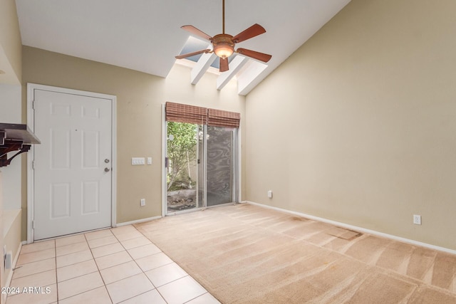 interior space featuring a ceiling fan, baseboards, light carpet, and high vaulted ceiling