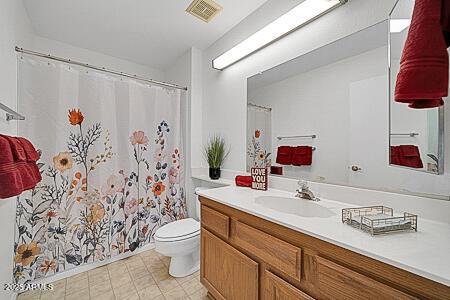 bathroom featuring vanity, a shower with curtain, visible vents, and toilet