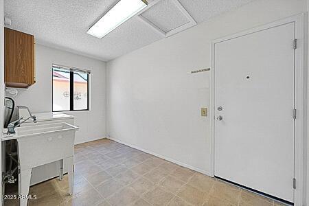 laundry room featuring a textured ceiling and a sink