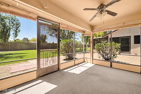unfurnished sunroom with ceiling fan