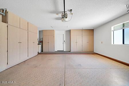 garage with baseboards and a garage door opener