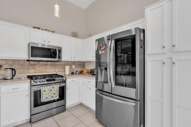 kitchen with tasteful backsplash, light tile patterned floors, light countertops, appliances with stainless steel finishes, and white cabinetry