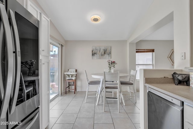 dining room with light tile patterned floors, baseboards, and plenty of natural light
