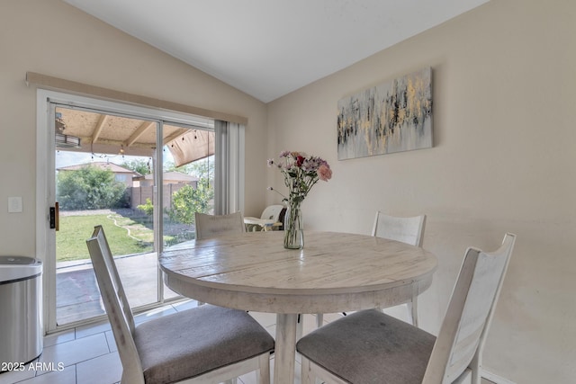 dining area with light tile patterned flooring and lofted ceiling