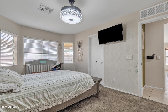 bedroom with light carpet, visible vents, and baseboards