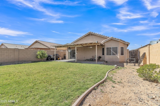 back of house featuring a yard, a patio, stucco siding, and a fenced backyard