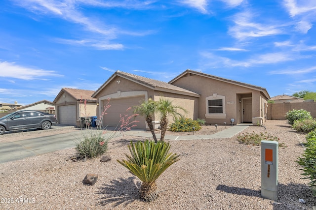 ranch-style home with a tiled roof, a garage, stucco siding, and driveway