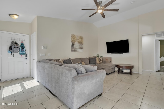 living area featuring light tile patterned floors, visible vents, vaulted ceiling, and ceiling fan