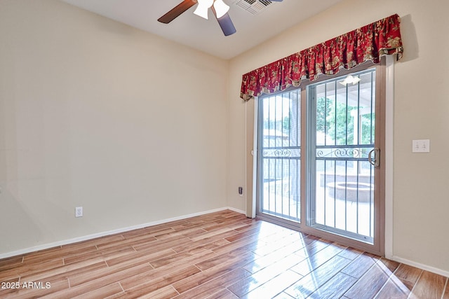 unfurnished room with light wood-type flooring, baseboards, visible vents, and a ceiling fan