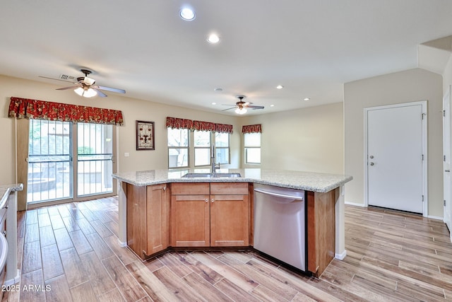 kitchen featuring a wealth of natural light, light wood-style flooring, dishwasher, and a sink