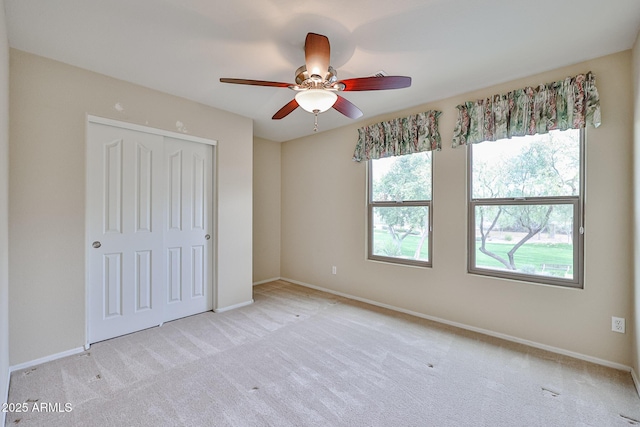 unfurnished bedroom with a closet, a ceiling fan, baseboards, and carpet floors