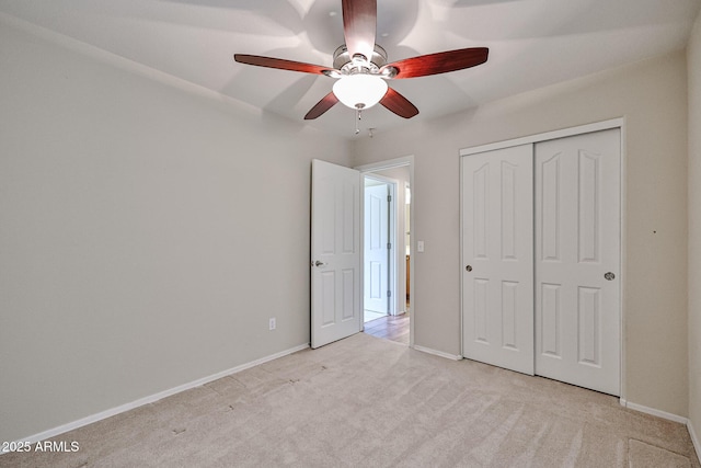 unfurnished bedroom with a closet, baseboards, and light colored carpet