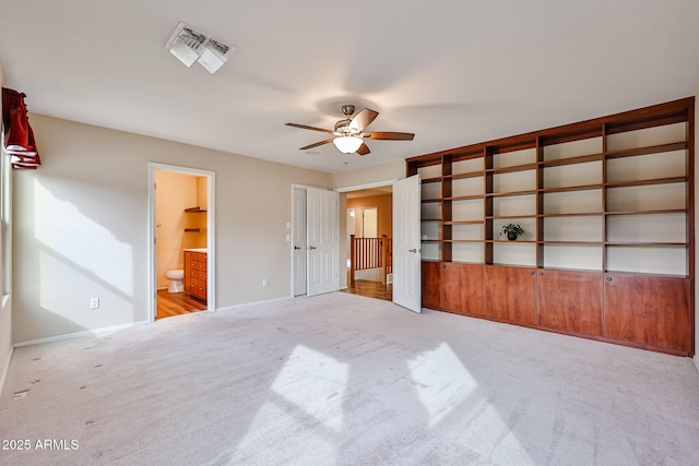 unfurnished bedroom with light colored carpet, visible vents, ensuite bathroom, and baseboards