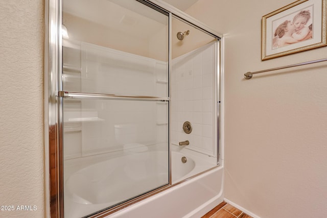 bathroom featuring combined bath / shower with glass door and wood finished floors