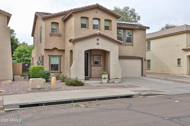 mediterranean / spanish home featuring fence, driveway, an attached garage, stucco siding, and a tile roof