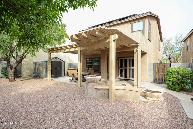 back of house featuring a storage unit, stucco siding, fence, an outdoor structure, and a patio area