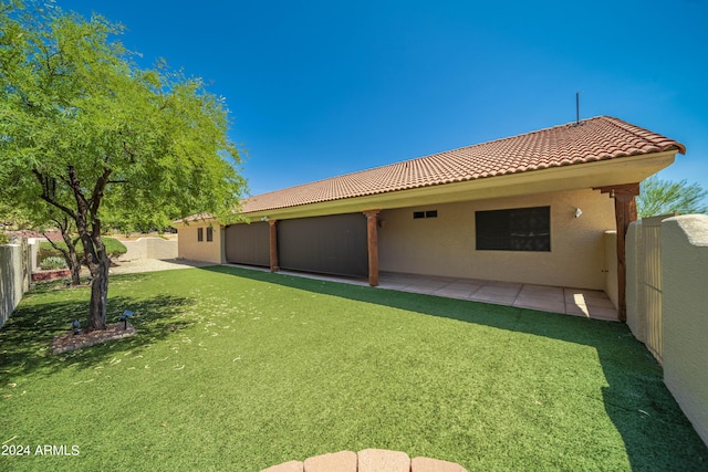 rear view of house with a lawn and a patio