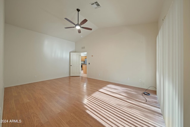 empty room featuring high vaulted ceiling, ceiling fan, and light hardwood / wood-style flooring