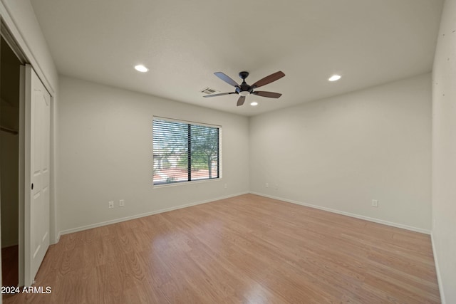 unfurnished bedroom with ceiling fan, a closet, and light wood-type flooring