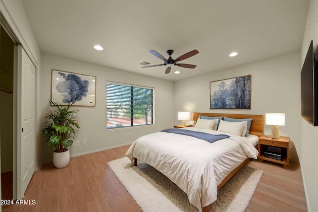 bedroom with ceiling fan, light wood-type flooring, and a closet