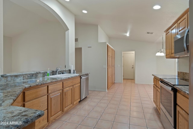 kitchen with sink, appliances with stainless steel finishes, hanging light fixtures, light tile patterned flooring, and vaulted ceiling