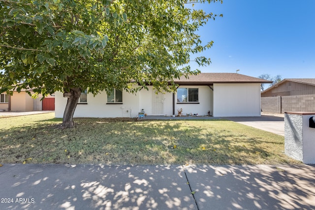 view of property hidden behind natural elements with a front yard